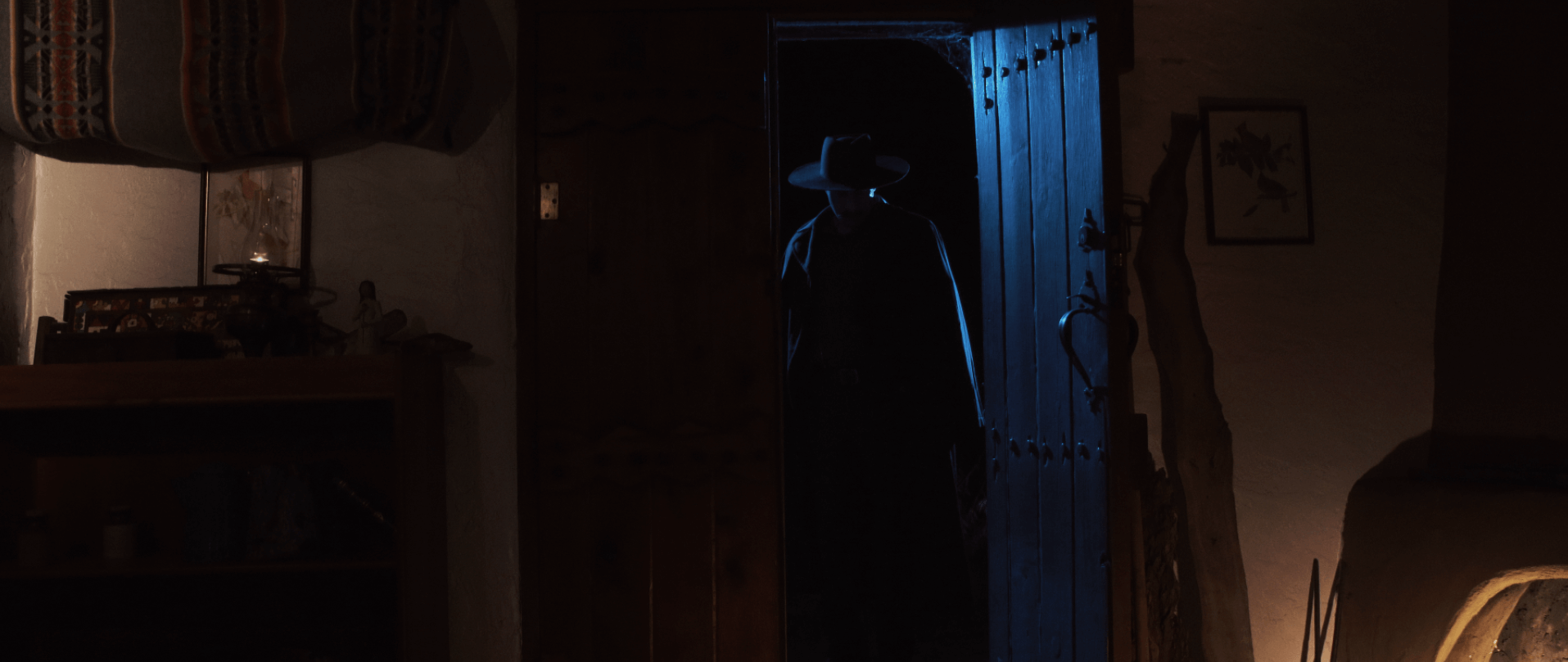 A young man stares in shock by lamplight